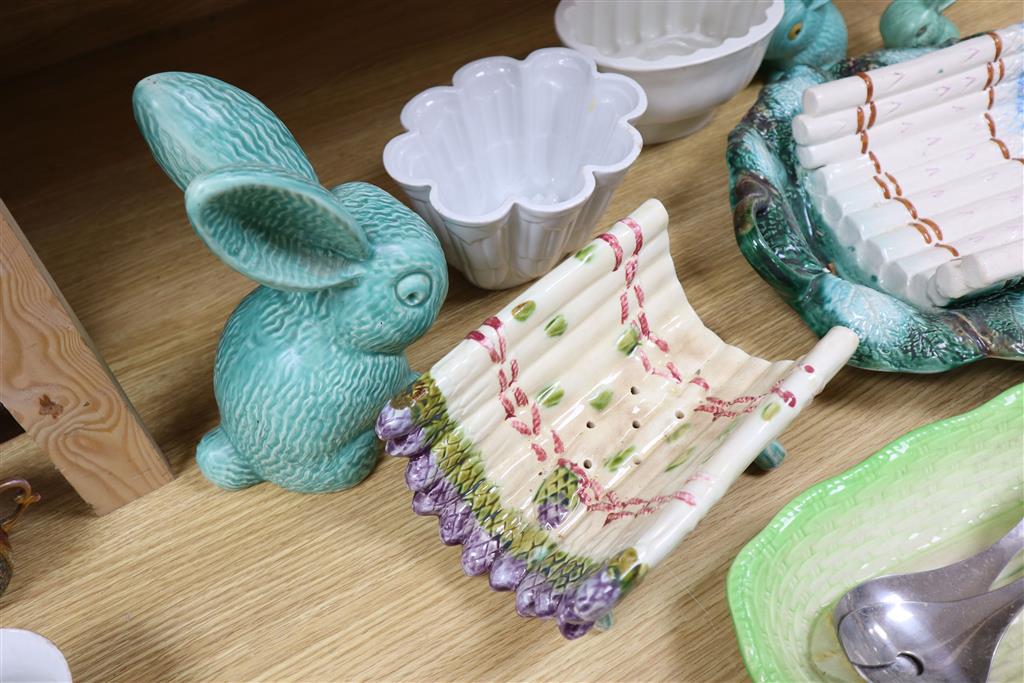 A Majolica style asparagus stand, a dish, graduated rabbits, a celery dish, and two jelly moulds, largest width 40cm